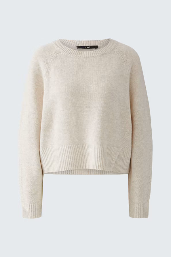 A light beige knit sweater with raglan sleeves and ribbed trim, displayed on a clean light gray background.