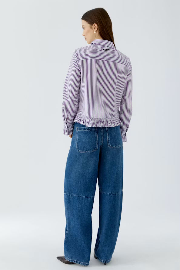 Person wearing a striped shirt and blue jeans on a white background
