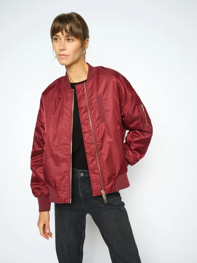 Person wearing a red bomber jacket on a white background