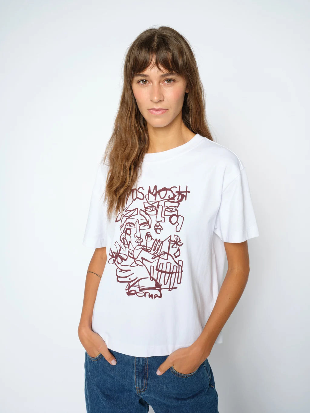 Person wearing a white t-shirt with red graphic design on a plain background