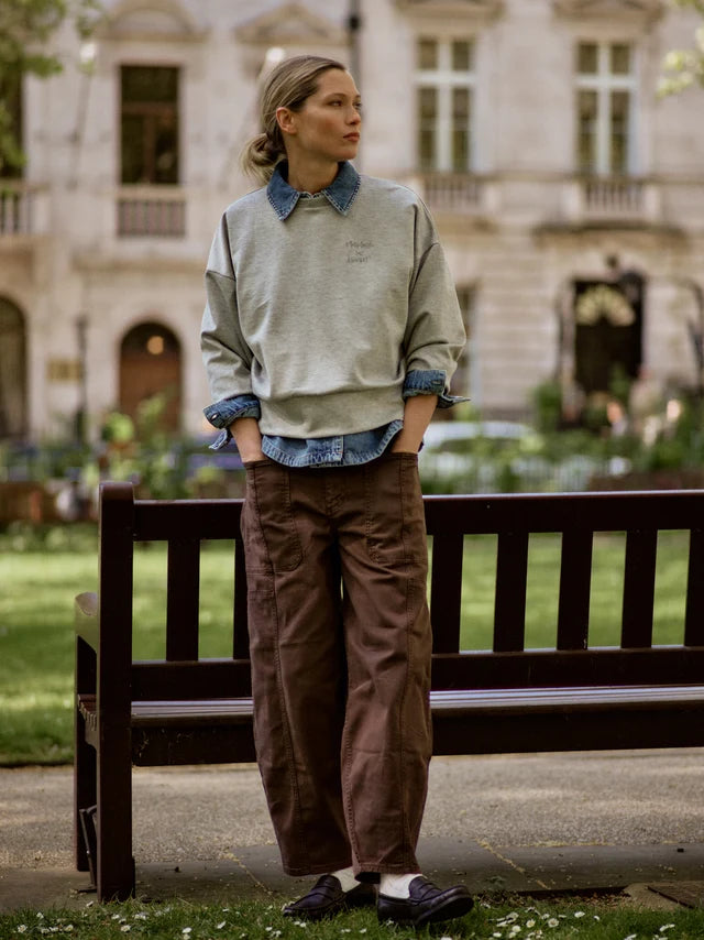 Person standing on a bench in an urban park setting