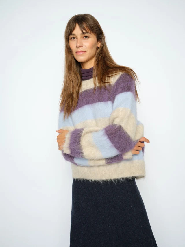 Woman wearing a multicolored sweater with a white background