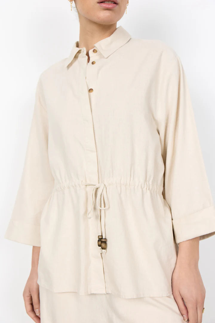 Beige shirt worn by a person on a white background