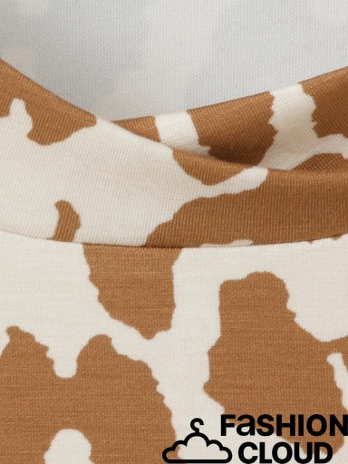 Close-up of a cow-print fabric garment, showing a brown and off-white pattern with a folded neckline. A 'FASHION CLOUD' watermark is visible in the bottom right corner.