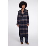 A model wearing a long navy and black plaid robe or coat with a shawl collar, paired with blue jeans and brown shoes, against a plain light gray background.