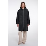 A model wearing a black hooded coat with beige pants, standing against a plain white studio background.