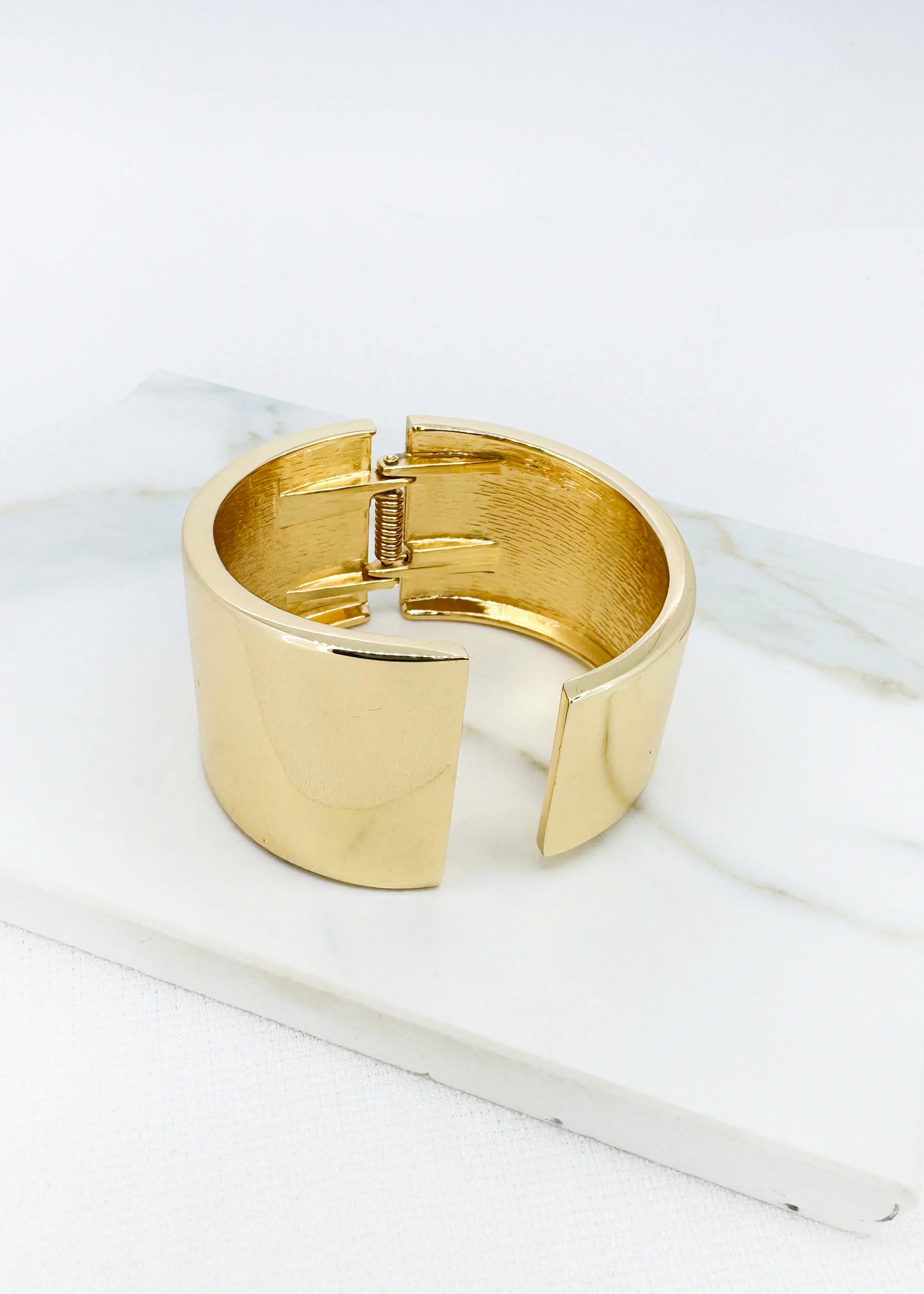 Envy gold-tone wide cuff bracelet showing its hinged opening and smooth open-front design from GM Boutique Claregalway, Galway, Ireland