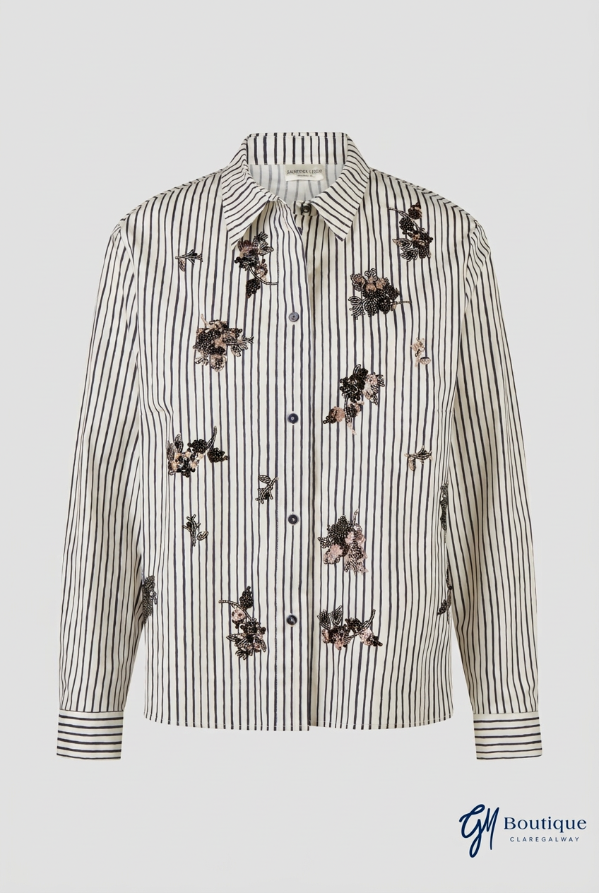 A long-sleeve button-up shirt with vertical black stripes on a cream/off-white base, decorated with scattered dark floral embroidery, shown against a light gray background.