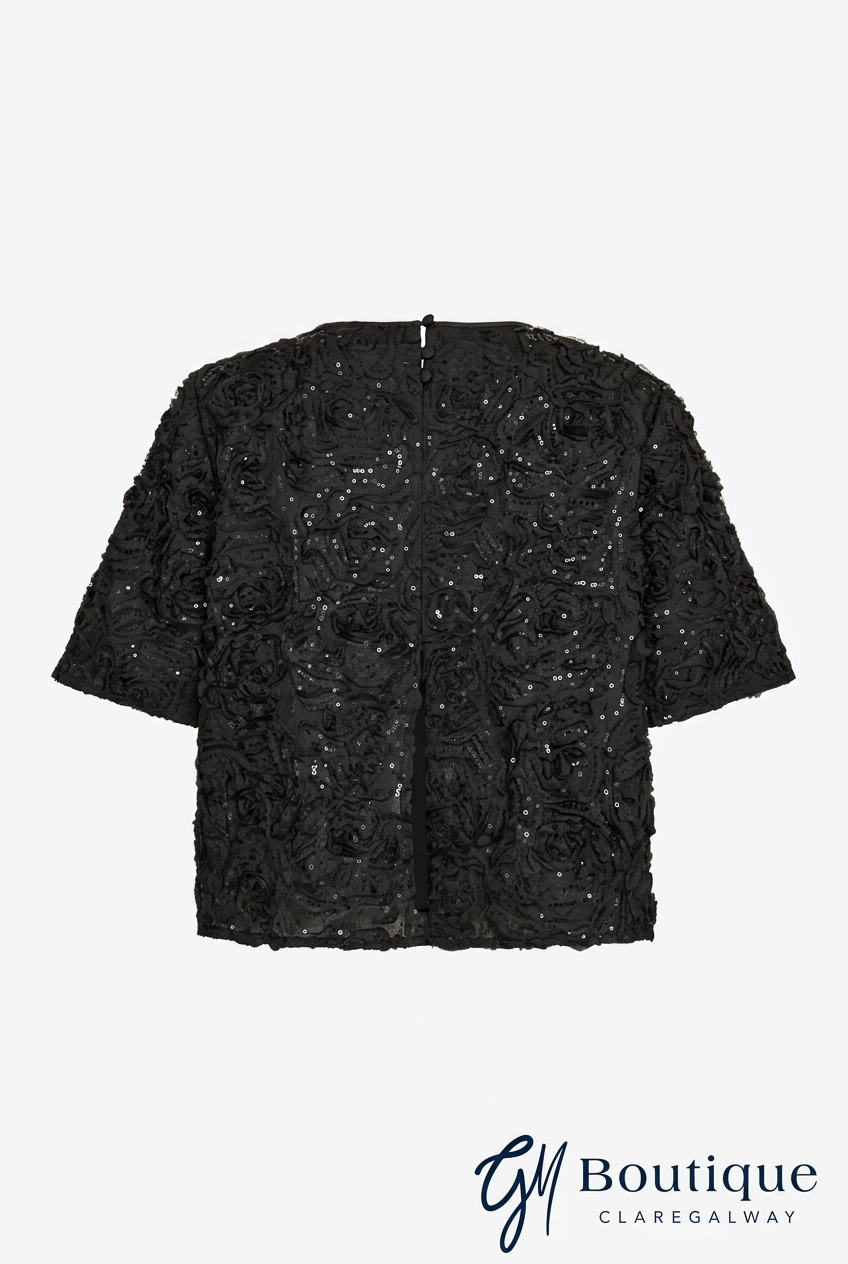A black short-sleeved top with intricate floral lace applique and sequined detailing, shown flat against a light gray background with a Boutique Claregalway watermark at the bottom.