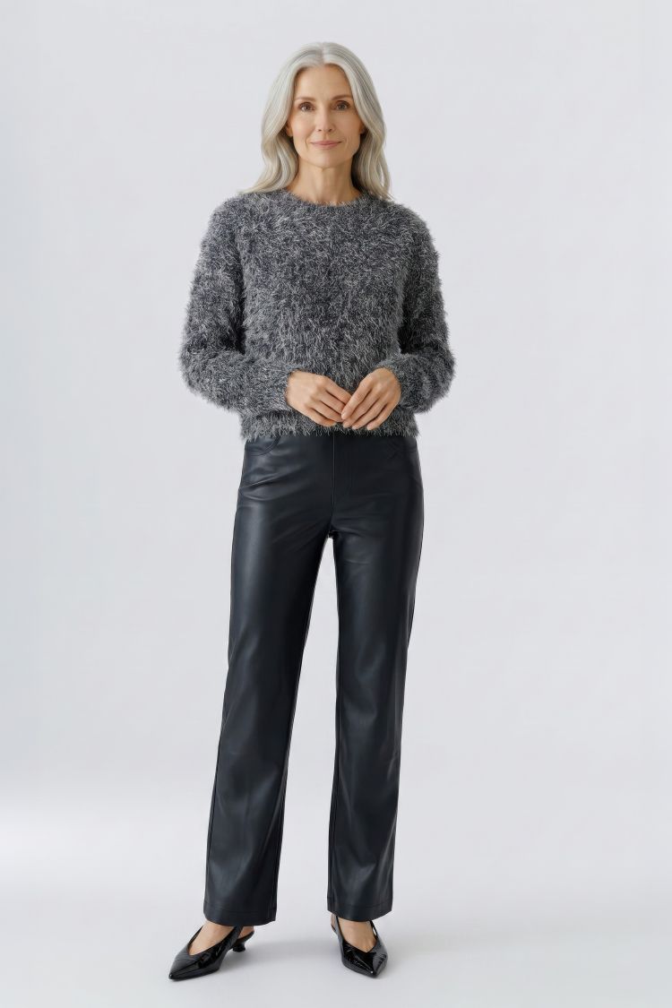 A woman stands against a light gray studio background wearing a fuzzy gray long-sleeve Oui sweater, black faux-leather pants, and black pointed flats. GM Boutique | Galway