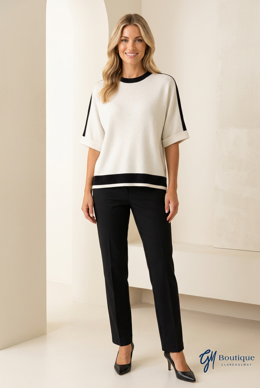 Women wearing Cream and Black top with black pants and shoes on neutral background with GM Boutique logo watermark