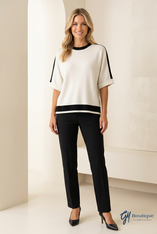 Women wearing Cream and Black top with black pants and shoes on neutral background with GM Boutique logo watermark
