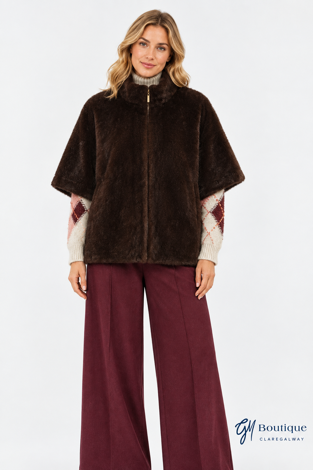 Model wearing the Micha cape closed with Oui argyle jumper and burgundy trousers with GM Boutique logo