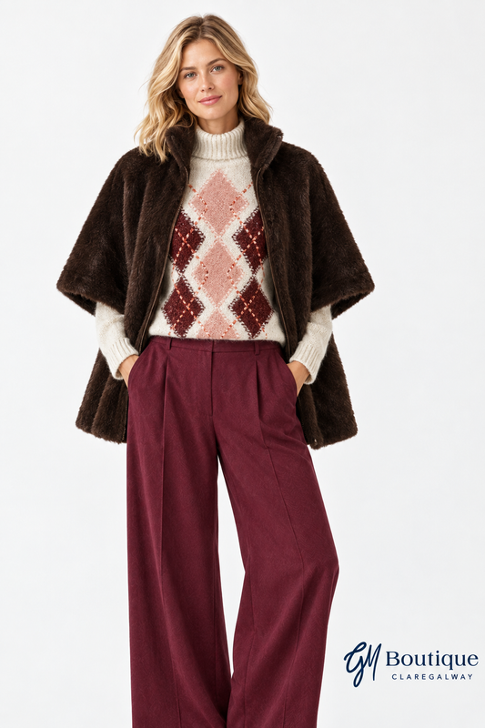 Model wearing the Micha faux fur cholcolate brown cape open with Oui argyle jumper and burgundy trousers with GM Boutique logo